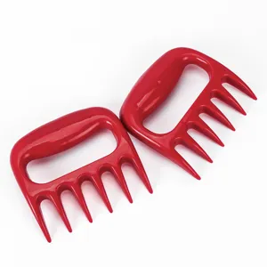 Gedetailleerde close-up van rode plastic vleesklauwen om eenvoudig barbecuevlees te versnipperen.