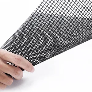 Black fiberglass non-stick BBQ grill mesh mat shown held in hand for outdoor cooking use.
