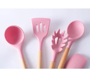 Close-up of pink silicone kitchen utensils with natural wooden handles for cooking and baking.