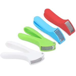 Close-up detail of manual garlic press with colorful handles and stainless steel mesh grid.