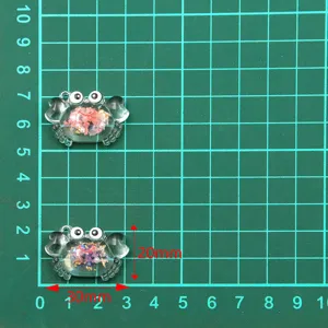 Transparent resin crab pendant DIY craft accessory with colorful floral fillings inside for necklace.