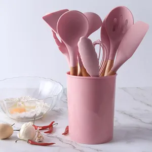 Pink silicone kitchen utensil set with wooden handles, non-stick cooking tools with holder.