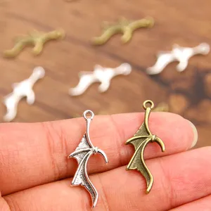 Close-up detail shot of bat wing metal charms pendants in silver and bronze colors DIY accessories.