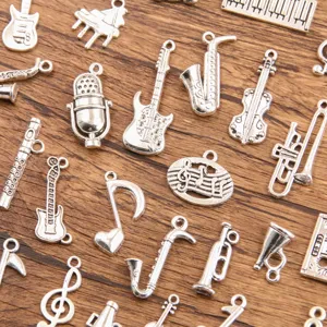 Detailed view of silver alloy musical instrument charms and note pendants for jewelry.