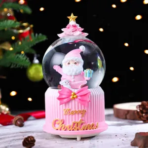 Roze kerst sneeuwbol muziekdoos detail, schattige Kerstman figuur en feestelijke basis.