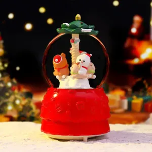 Detail van de kerstspeeldoos met de schattige sneeuwpopfiguur en het draaiende carrouselontwerp.