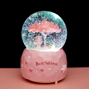 Gedetailleerd uitzicht op de schattige glow roze sneeuwbol met kersenboom en zacht licht.