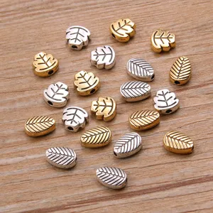 Detail shot of metal leaf beads in gold and silver, ideal for DIY bracelets and necklaces.