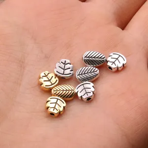 Detailed view of DIY alloy leaf beads, dual color gold and silver metal charms for jewelry.