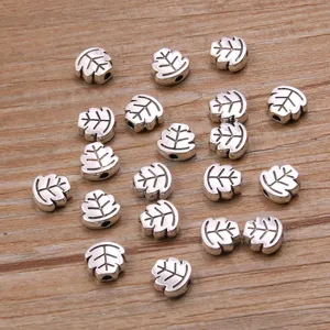 Close up detail shot of silver leaf alloy metal beads for DIY handmade jewelry crafts.