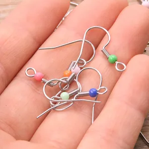 Close-up detail of DIY stainless steel earring hooks with colorful beads for jewelry making.