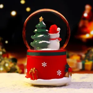 Christmas snow globe detail with cute snowman tree inside warm glowing music box home decor