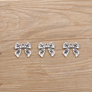 Vintage bow charm pendants for DIY jewelry making and phone accessories, silver tone item.