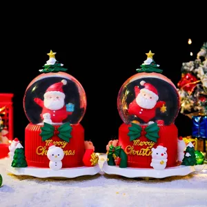 Nahaufnahme einer süßen Weihnachts-Schneekugel mit Leuchteffekt und festlicher Tischdeko.