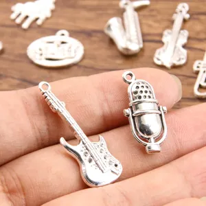 Close-up detail of silver alloy music charms featuring miniature guitar and microphone pendants.