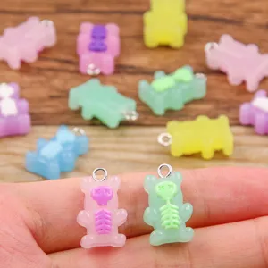 Gros plan détaillé de charmants pendentifs ours squelette en résine colorée pour bijoux DIY.