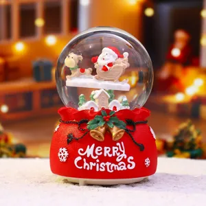 Nahaufnahme der Weihnachtsschneekugel mit Weihnachtsmann und Schlitten, leuchtende Deko.
