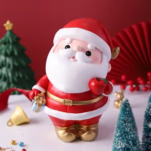 Mignonne figurine de Père Noël en résine avec boîte-cadeau et pomme pour déco de Noël et tirelire.