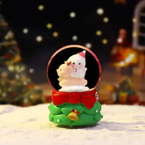 Detailed close-up of a mini Christmas snow globe featuring a cute snowman and reindeer inside.