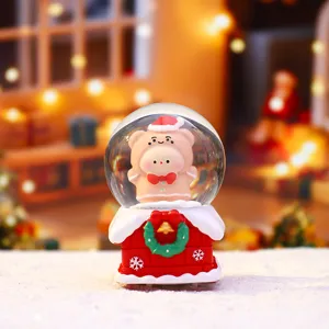 Gros plan détaillé de la mini boule à neige de Noël lumineuse avec un charmant socle cabane.