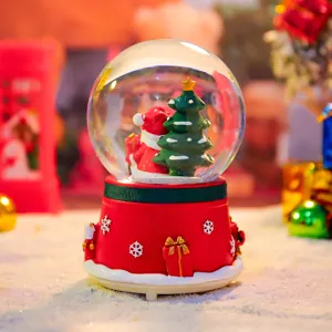 Christmas snow globe detail showing cute Santa Claus and tree inside with red snowflake base.