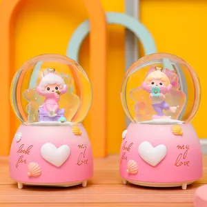 Detailansicht der rosa Harz Schneekugeluhr mit niedlichen Fantasie-Cartoon-Figuren.