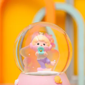 Süße Unterwasserwelt Schneekugel Spieluhr mit rosa Sockel und verträumter Cartoon Figur.