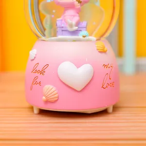 Rosa Schneekugel Spieluhr mit süßen Figuren, Muschel-Dekor und Herz für tolle Geschenke.
