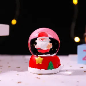 Weihnachtsschneekugel Detail mit leuchtender Weihnachtsmann Figur und festlicher Deko.