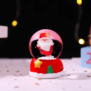 Nahaufnahme Detail der Weihnachtsschneekugel mit Weihnachtsmann Figur und Leuchtkugel.