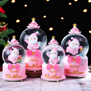 Detailed close-up of cute pink Christmas snow globes with adorable Santa Claus figures inside.