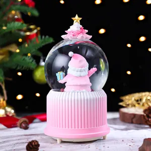Pink Christmas snow globe featuring cute Santa Claus and tree, perfect holiday desktop decor detail.