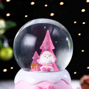 Nahaufnahme der rosa Weihnachts-Schneekugel mit niedlichem Weihnachtsmann und schöner Beleuchtung.