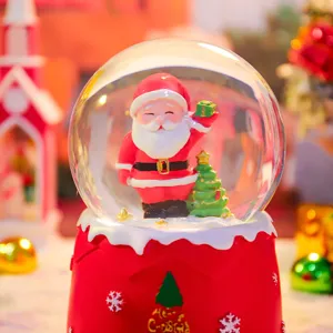 Gedetailleerde close-up van een feestelijke kerstsneeuwbol met de Kerstman en verlichting.