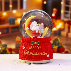 Nahaufnahme der süßen Weihnachtsschneekugel mit Weihnachtsmann und rotem Stricksockel.