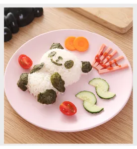 Primo piano dettaglio di simpatica presentazione cibo stampo riso panda su piatto rosa.