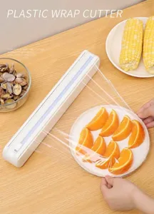 Detalle del práctico cortador de film plástico con cuchilla deslizante y fruta.