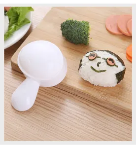 Detail view of cute cartoon rice ball mold showing finished seaweed sushi on wooden board