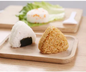 Detailansicht von hausgemachten dreieckigen Onigiri-Reisbällchen auf Holztabletts mit frischem Salat.