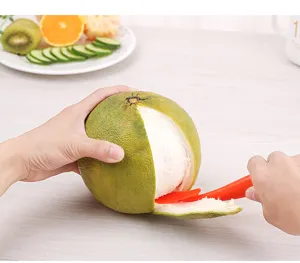 Primo piano del pelarance in uso, pratico strumento da cucina per frutta fresca.