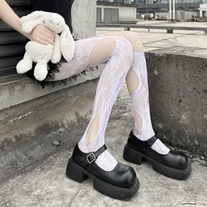 Detail shot of white fishnet cut-out tights paired with black platform Mary Jane shoes.