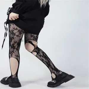 Detailed view of women's black hollow-out fishnet tights with cutout knee design.