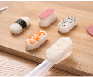 Detailed view of a clear plastic sushi rice mold tool placed on a wooden background for DIY bento.