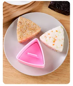 Vista dettagliata dello stampo per polpette di riso triangolari rosa in plastica per sushi.