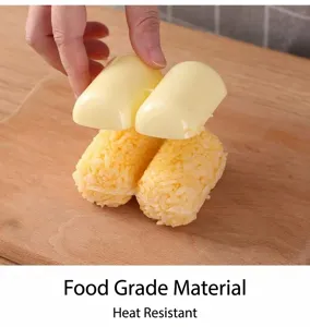 Close-up detail of hands using a yellow two-cavity plastic rice ball mold to shape sushi.