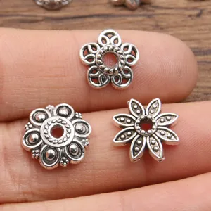 Close-up detail van antiek zilveren bloemvormige tussenkralen voor sieraden maken.