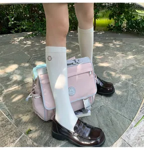 Detailweergave van Japanse JK-stijl witte sokken tot halverwege de kuit met leuk borduursel.