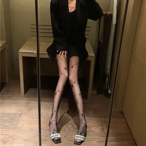 Schwarze Netzstrumpfhose für Damen mit schickem Sternenmuster und funkelnden Linien.