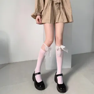 Detailed view of summer thin white knee-high socks with cute sheer bow decoration for women.