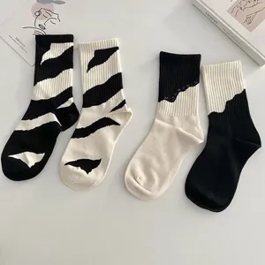 Asymmetric black and white striped and color-block casual long socks, trendy streetwear style.